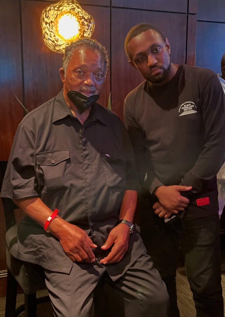Chas Moore seated at a community gathering alongside another community member